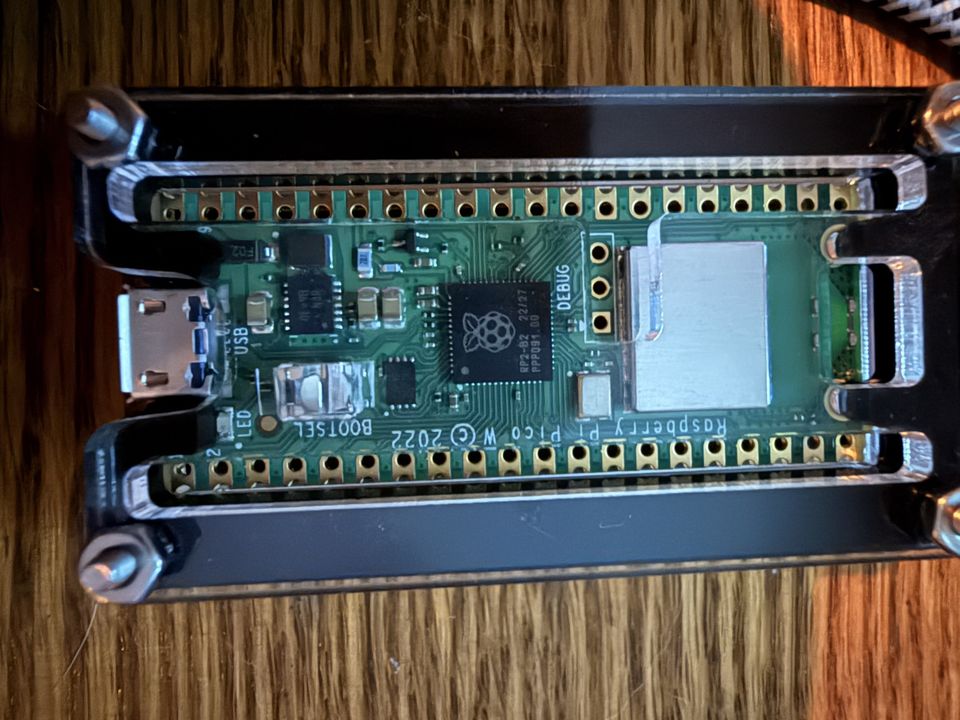The BadUSB I built: a Raspberry Pi Pico W in a clear case on a wooden table